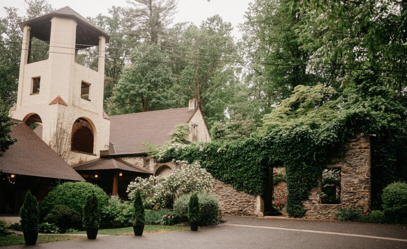 The Old Mill building, tan stone with archways, open windows, and vines