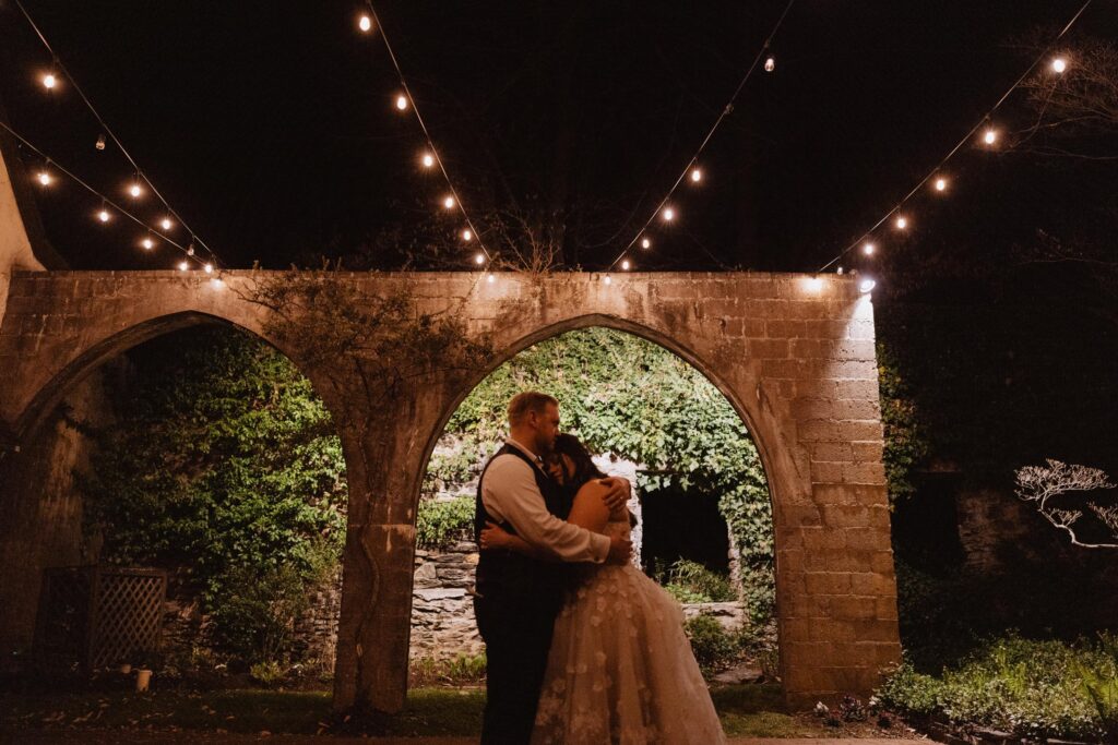 Newlyweds share a private dance under the lights.