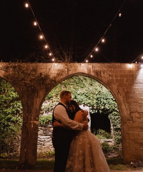 Newlyweds share a private dance under the lights.