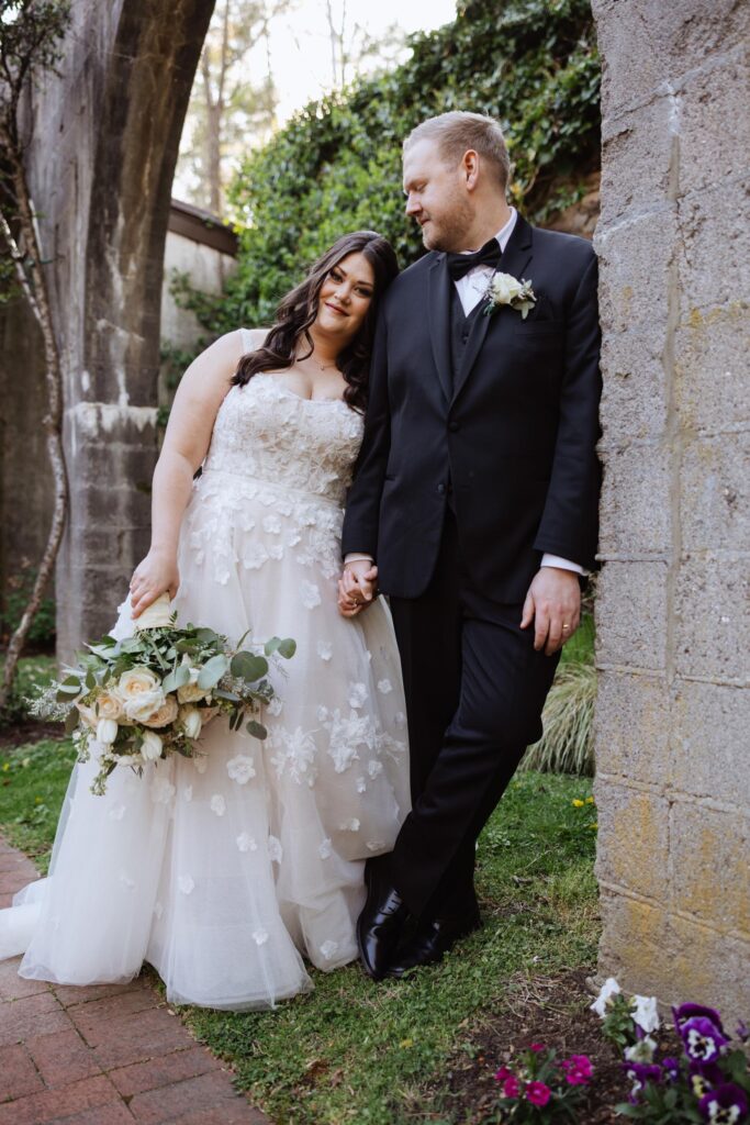 Newlyweds holding in archway.