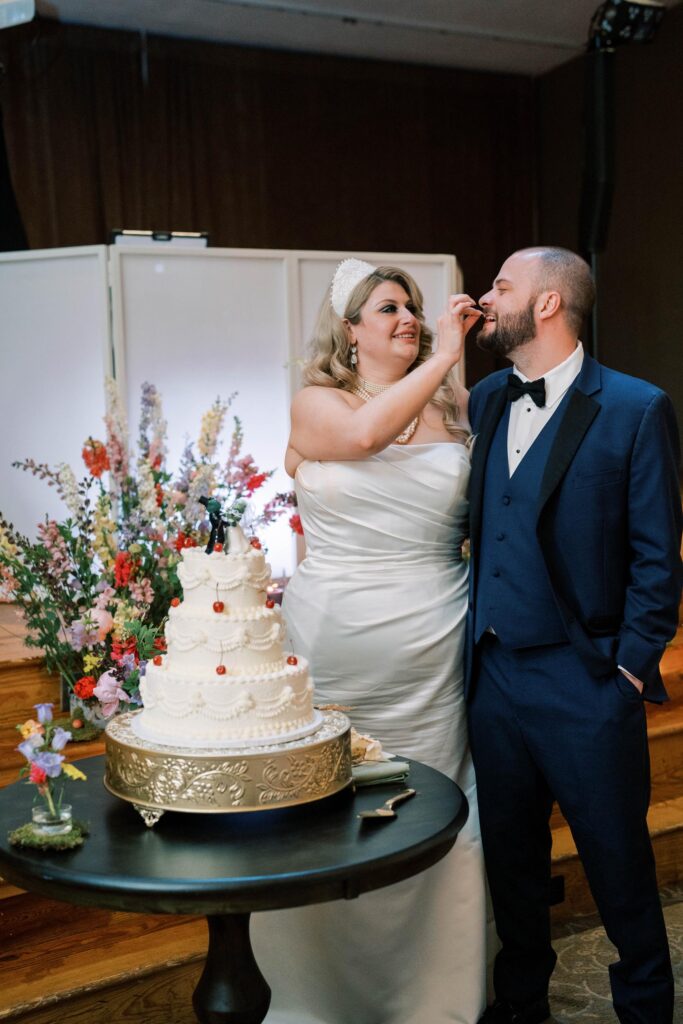 Newlyweds cutting and eating cake.