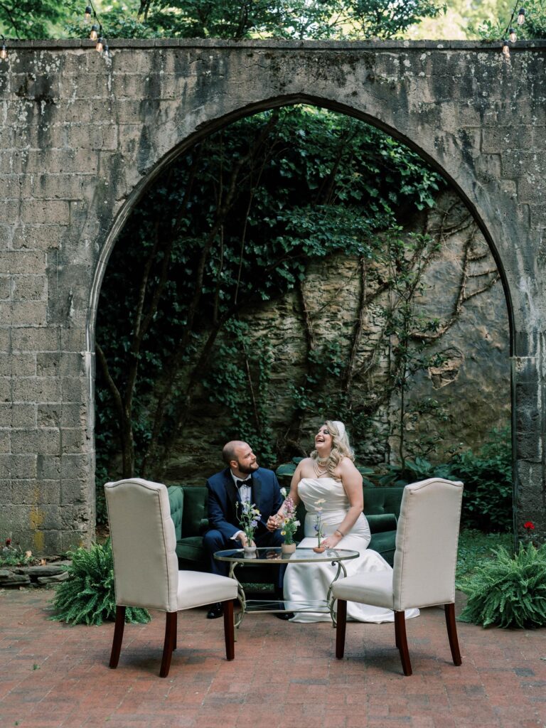 Newlywed in archway sitting in the lounge outside in the garden.