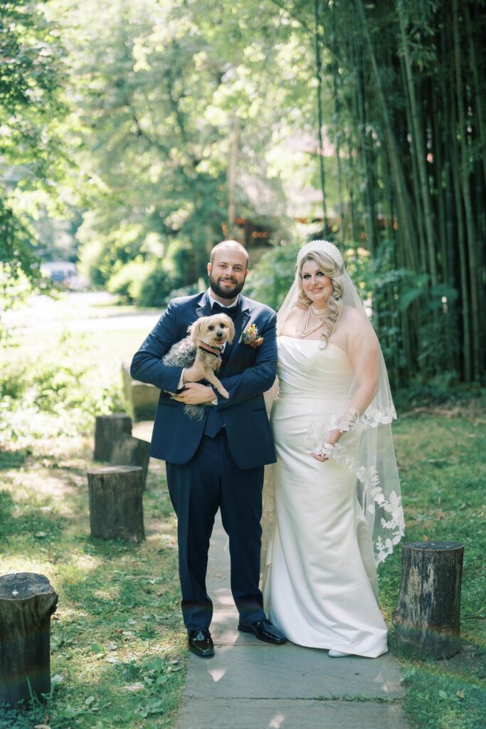 Newlyweds with their puppy in the garden.