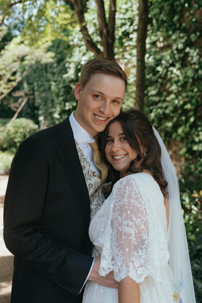 Newlyweds hugging and smiling in the garden.