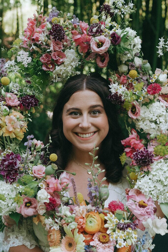 Bride smiling circled by her bridesmads bouquets.