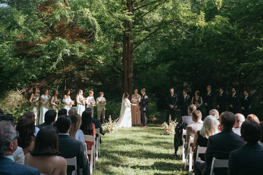 Newlyweds share their vows in the garden in front of guests.